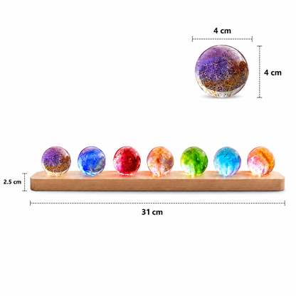 Infographie présentant les dimensions du kit de sphères lumineuses décoratives Lumina. La base en bois mesure 31 cm de longueur et accueille sept sphères en verre de 4 cm de diamètre. Visuel sur fond blanc mettant en valeur les dimensions et les couleurs du kit.