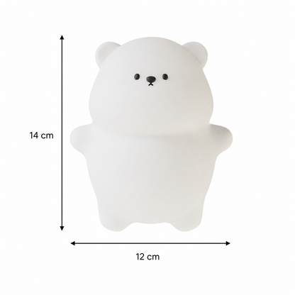 Infographie présentant les dimensions de la veilleuse ourson en silicone blanc. Le produit est affiché sur un fond blanc avec des flèches indiquant une hauteur de 14 cm et une largeur de 12 cm, permettant de visualiser facilement son format compact.
