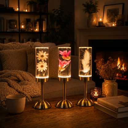 Collection Little Daisy composée des lampes Marguerite, Lotus Rose et Plume illuminant un salon chaleureux avec foyer, créant une ambiance douce et apaisante.