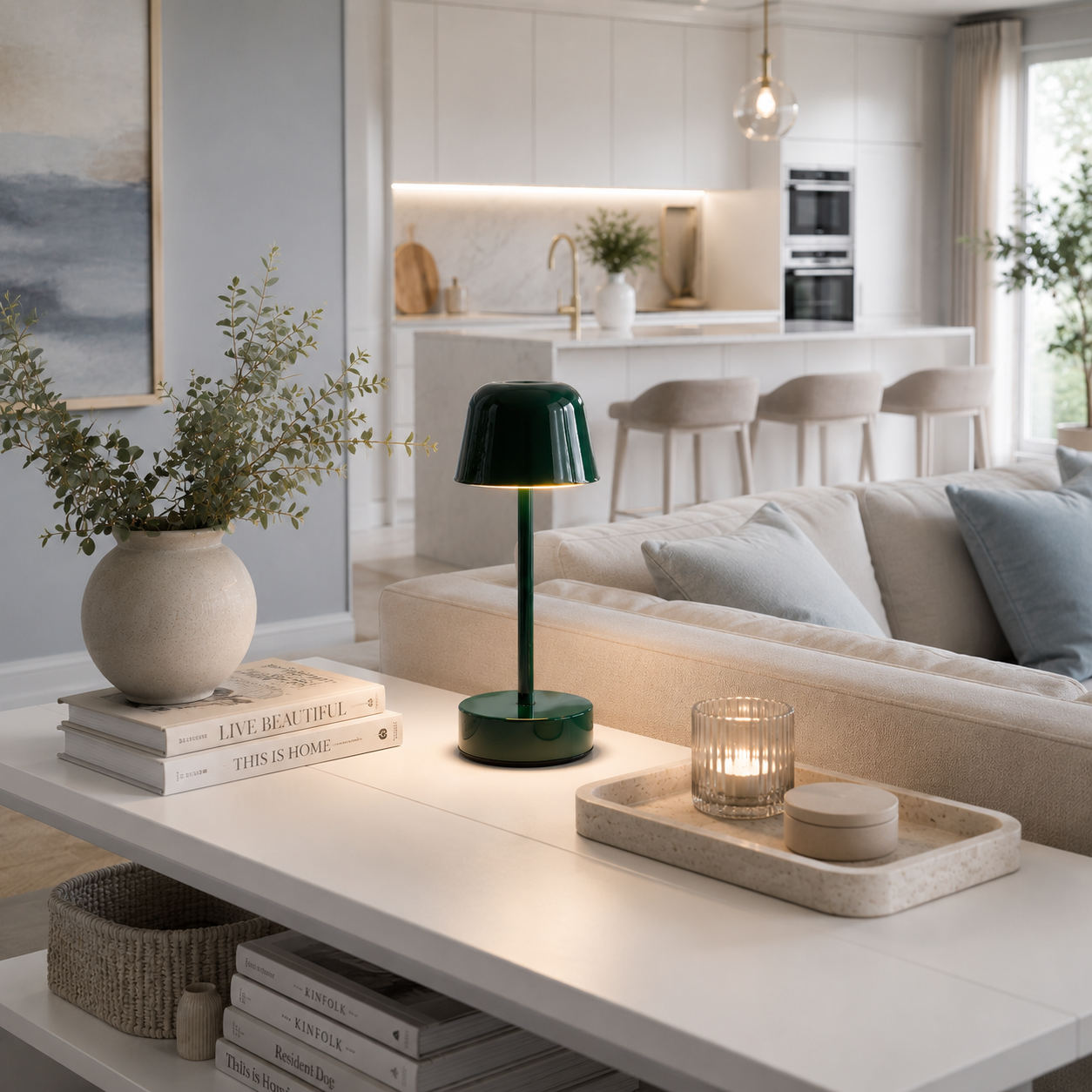Lampe Nova LED rechargeable vert forêt sur une console blanche dans un salon moderne avec cuisine ouverte, décoration élégante et intérieur lumineux aux tons greige et bleu poudre.