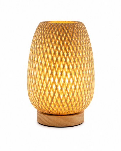 Lampe de table Tressa en bambou tressé à la main avec base en bois naturel, éclairage LED diffusant une lumière douce et chaleureuse. Lampe décorative au design artisanal sur fond blanc, idéale pour le salon, la chambre, le bureau, l'entrée ou une table de chevet.