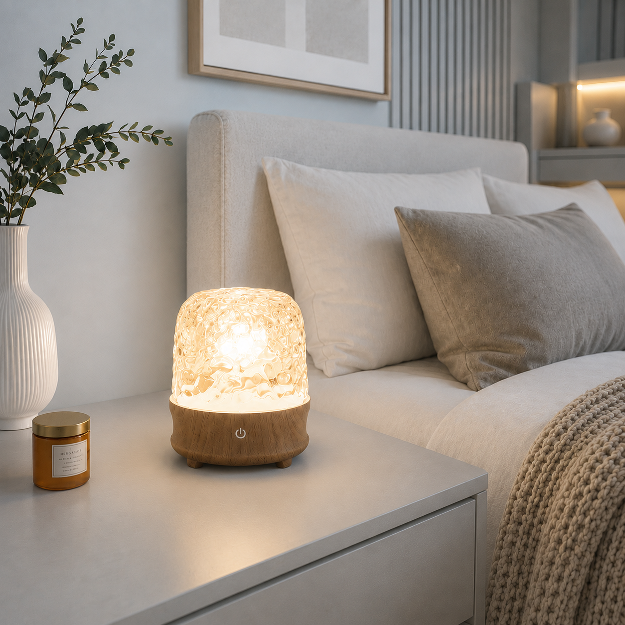 Lampe reflets d’eau LED Luméa diffusant une lumière douce sur une table de chevet dans une chambre moderne aux tons greige, créant une ambiance apaisante et chaleureuse.