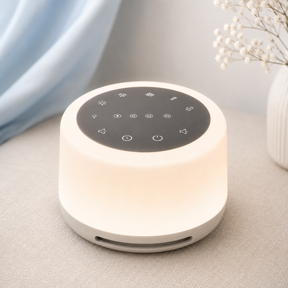 Veilleuse bébé avec bruits blancs et lumière douce posée sur une table de nuit, dans une chambre aux tons greige et bleu poudre, idéale pour favoriser un sommeil paisible des bébés et jeunes enfants.