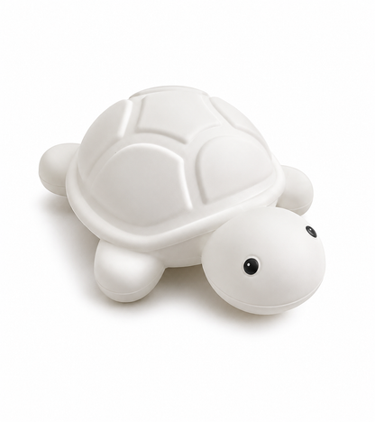 Veilleuse tortue apaisante rechargeable en silicone sur fond blanc, offrant une lumière douce pour rassurer les bébés et les enfants au moment du coucher.